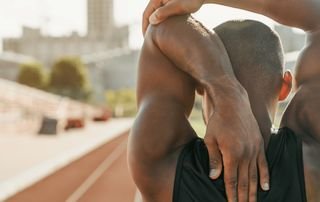 Palm Beach orthopedist assessing shoulder range of motion in a patient with frozen shoulder