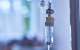 Intravenous fluid bag and line prepared for a patient being treated for dehydration in a clinical setting
