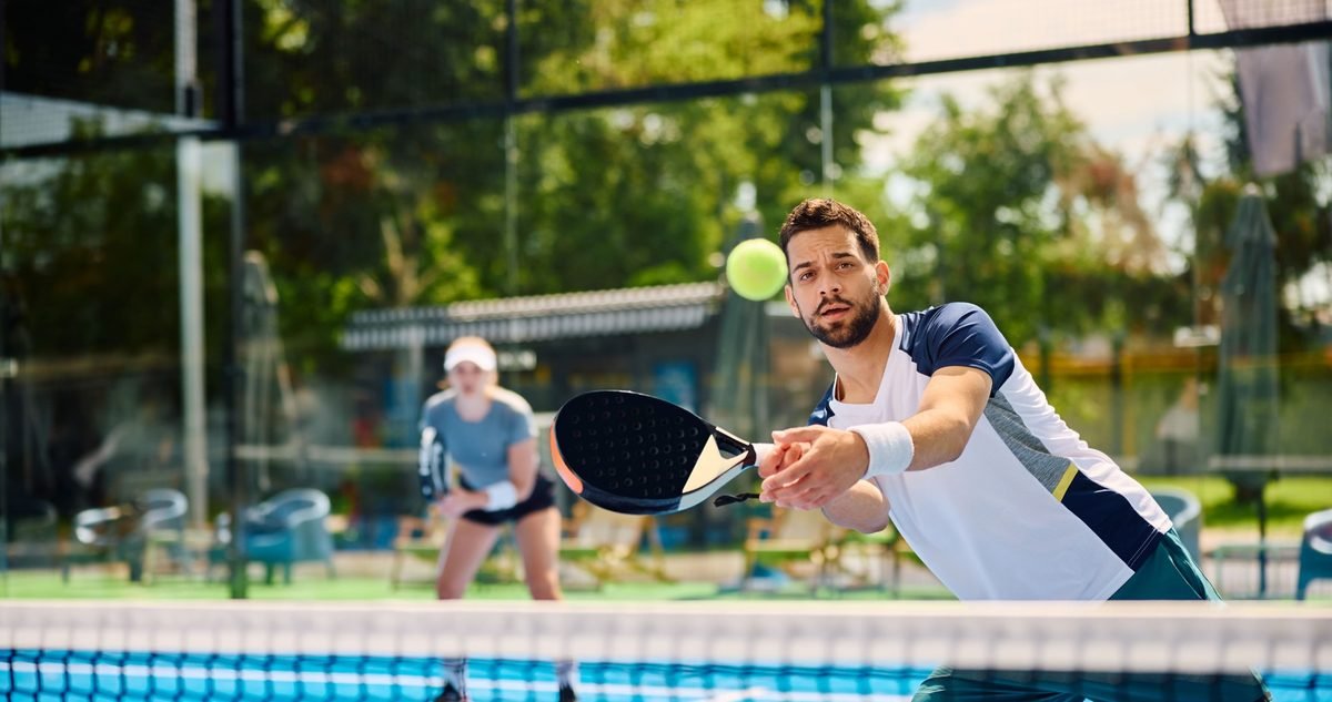 When to See a Sports Medicine Doctor in Delray Beach Padel player reaching for a volley at the net, the kind of repeated load that brings players to a sports medicine clinic.