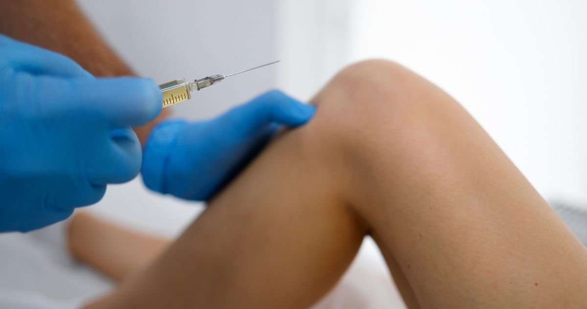 Injection for persistent joint pain and inflammation Gloved clinician injecting a patient’s knee to treat joint pain and inflammation at an orthopedic office in Delray Beach.